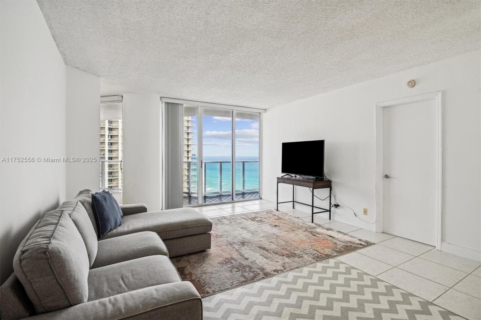 Open Layout Living Area with Entrance to Balcony.