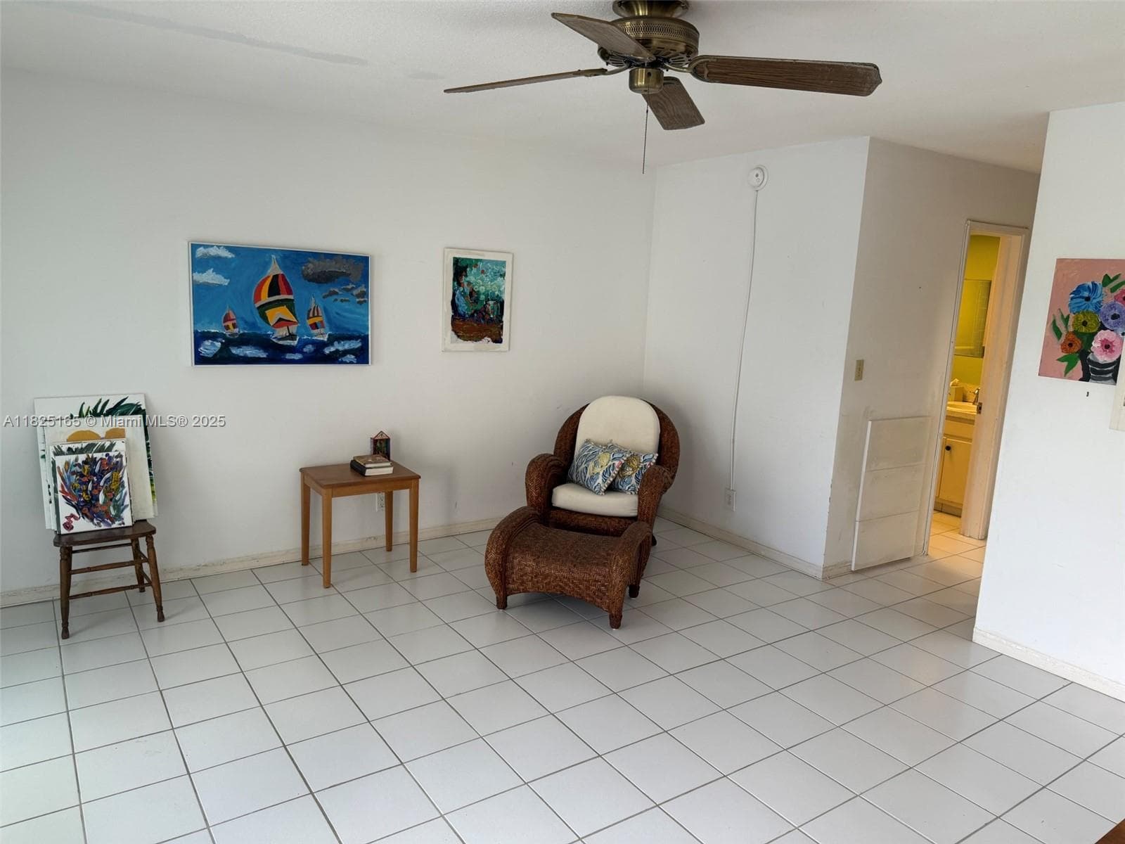 Bright living room with wall AC and ceiling fan