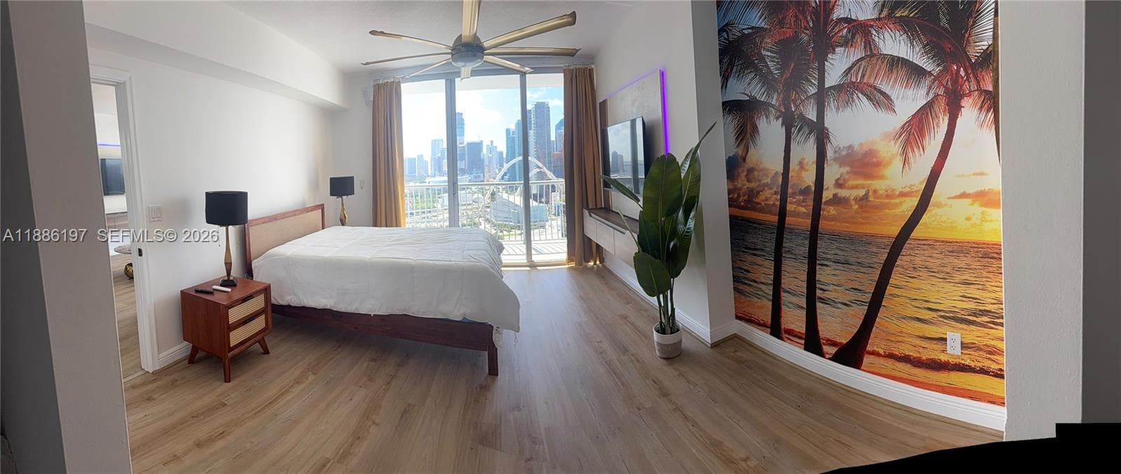 Wood-finish flooring, floor-to-ceiling glass panel windows, integrated ceiling fan, and wall-mounted floating cabinetry