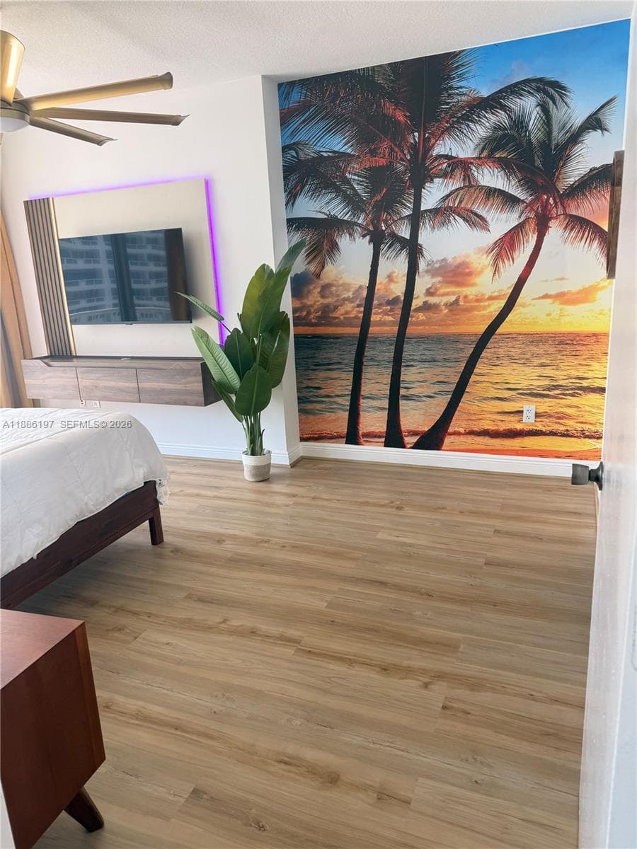 Wood-finish flooring throughout, wall-mounted floating cabinetry, and ceiling-mounted fan with integrated lighting