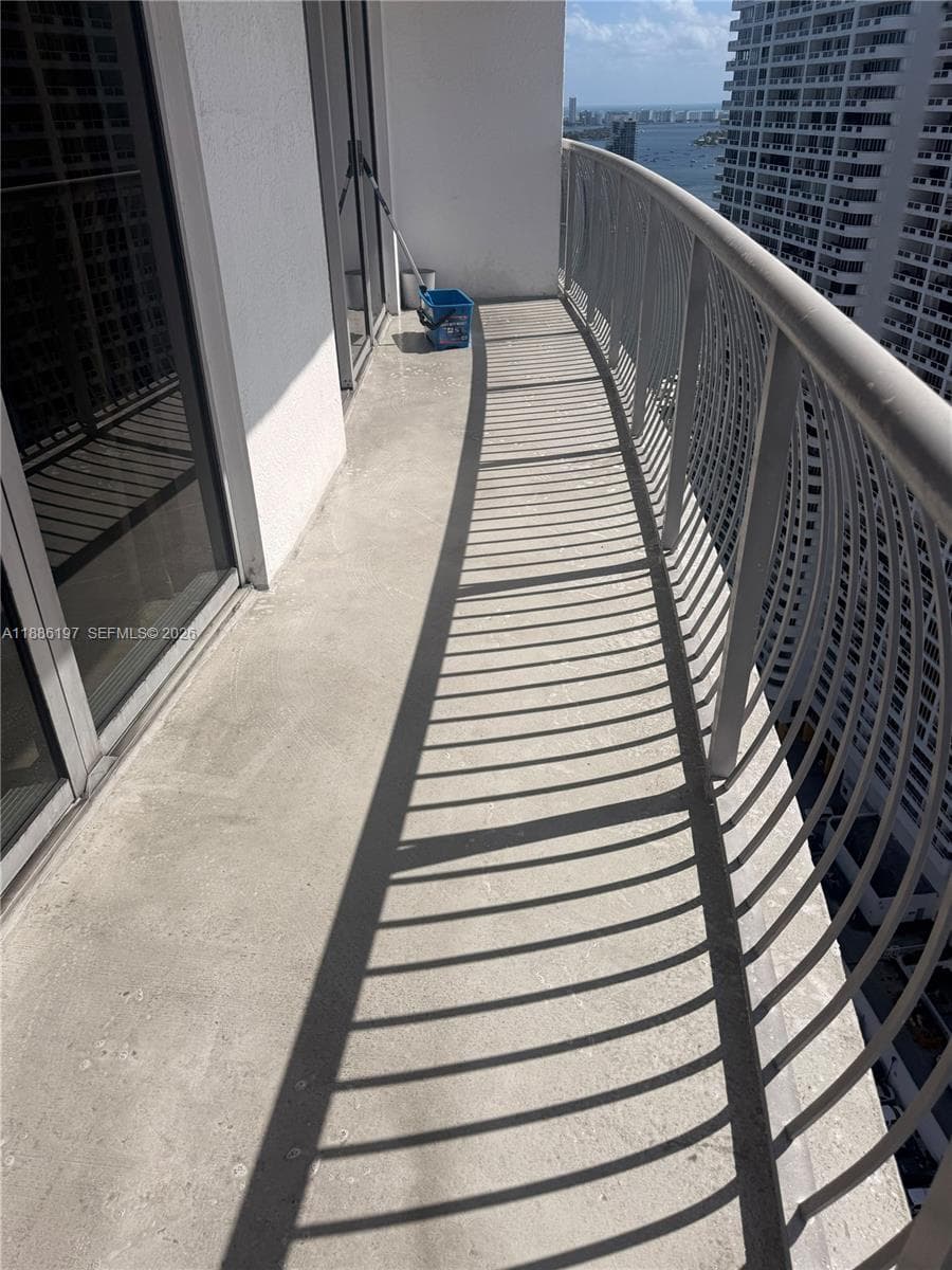 Curved balcony featuring a concrete floor and a metal railing
