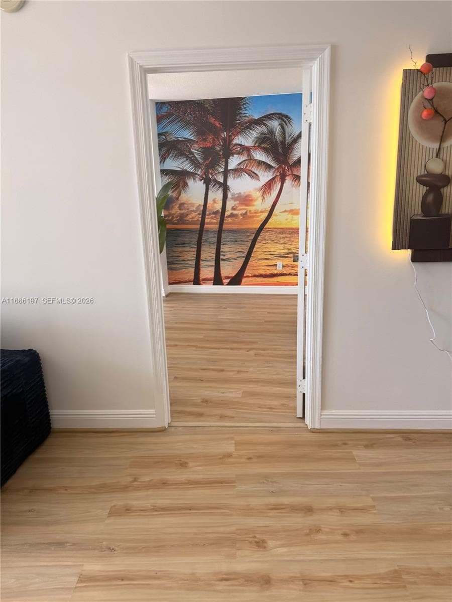 Wood-finish flooring throughout, featuring crisp white door casing and neutral wall finishes