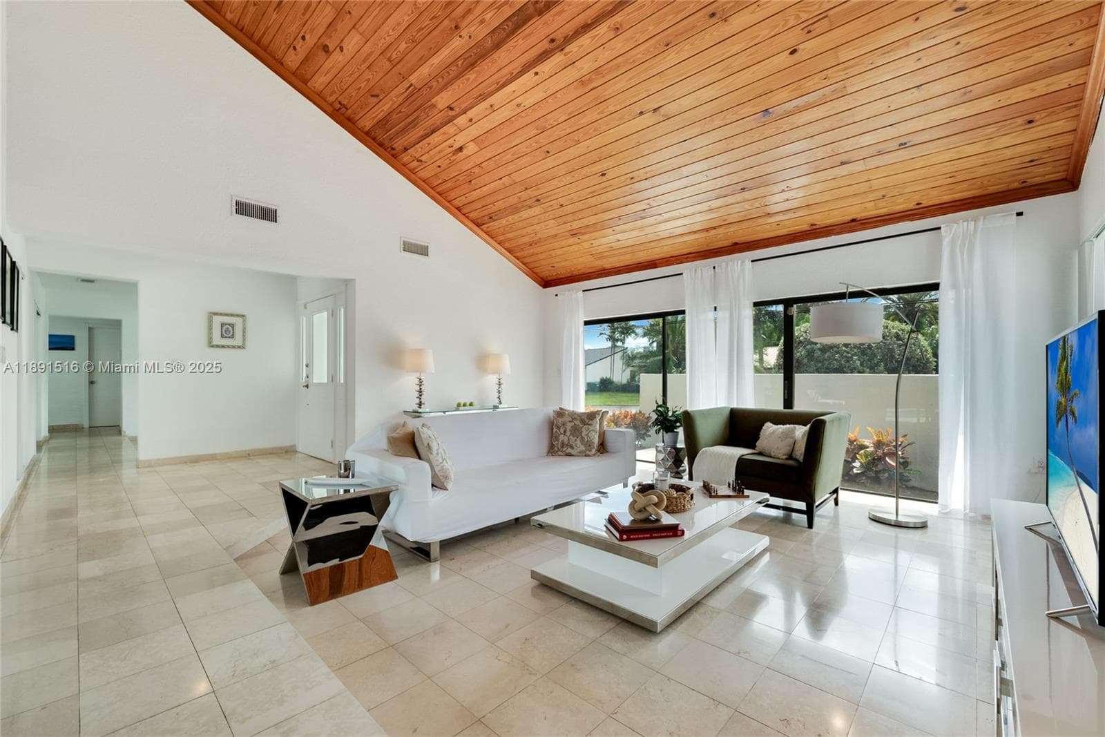 Living room with high ceilings and abundant natural light, offering direct access to the large patio and a private front terrace. Split Floorplan.