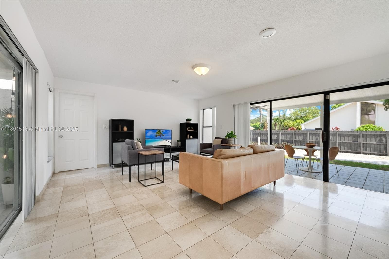 Family or dining room with large sliding doors on both sides, opening to the covered patio and a private second terrace — filled with natural light throughout.