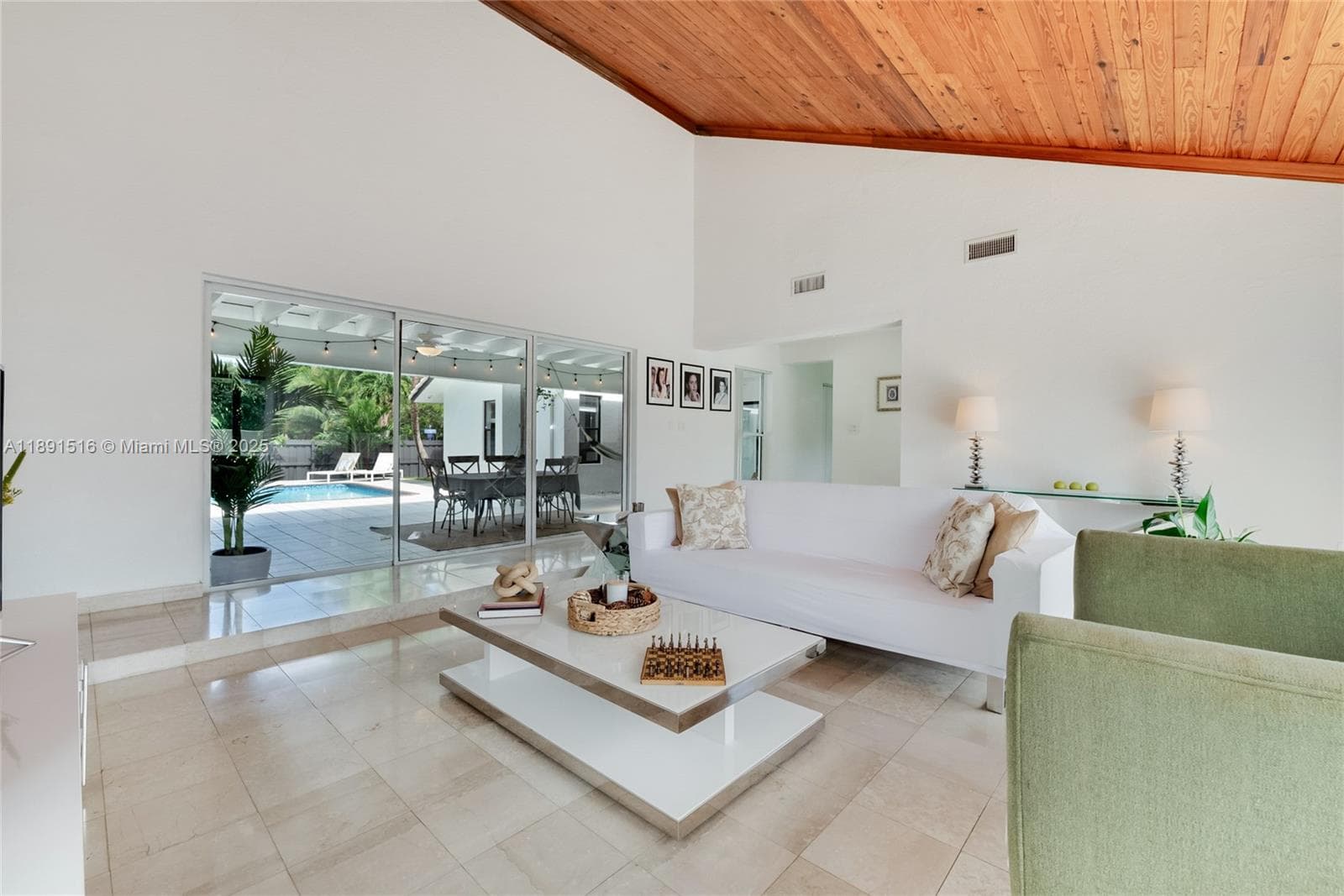 Living room with high ceilings and abundant natural light, offering direct access to the large patio and a private front terrace.