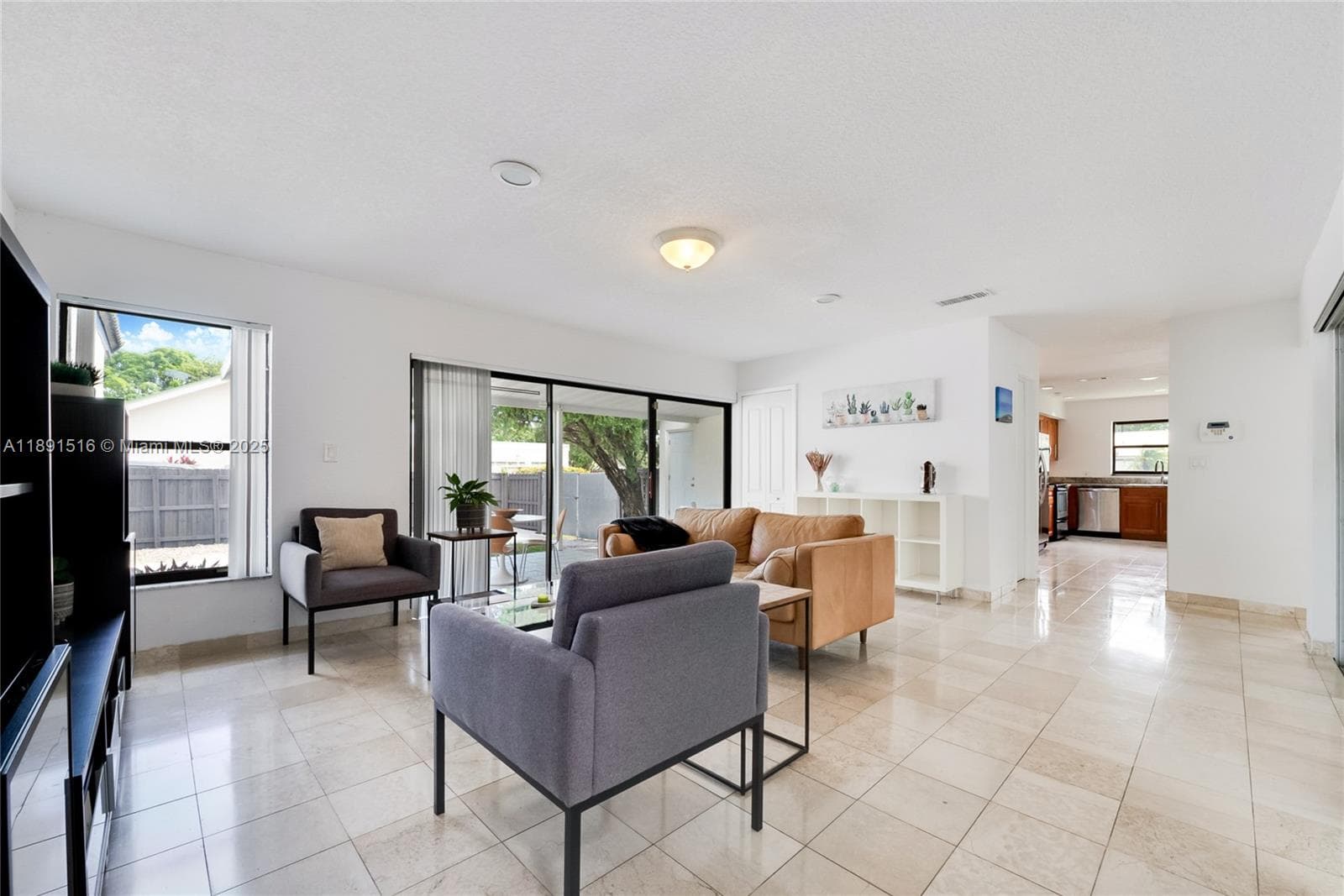 Family or dining room with large sliding doors on both sides, opening to the covered patio and a private second terrace — filled with natural light throughout.