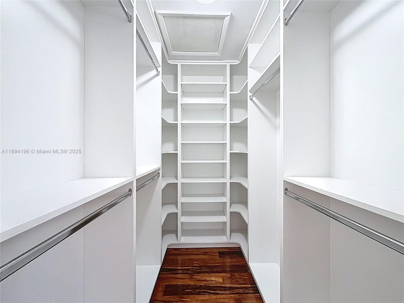 Primary Closet with Floor to Ceiling Shelves.