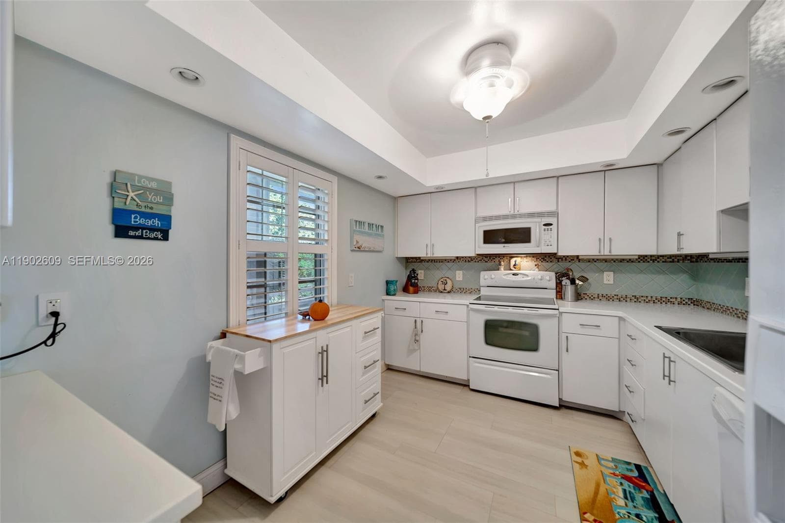 Open-concept dining and living space designed for entertaining, with crown accents, generous ceiling height, and seamless flow into the kitchen and out to the view.
