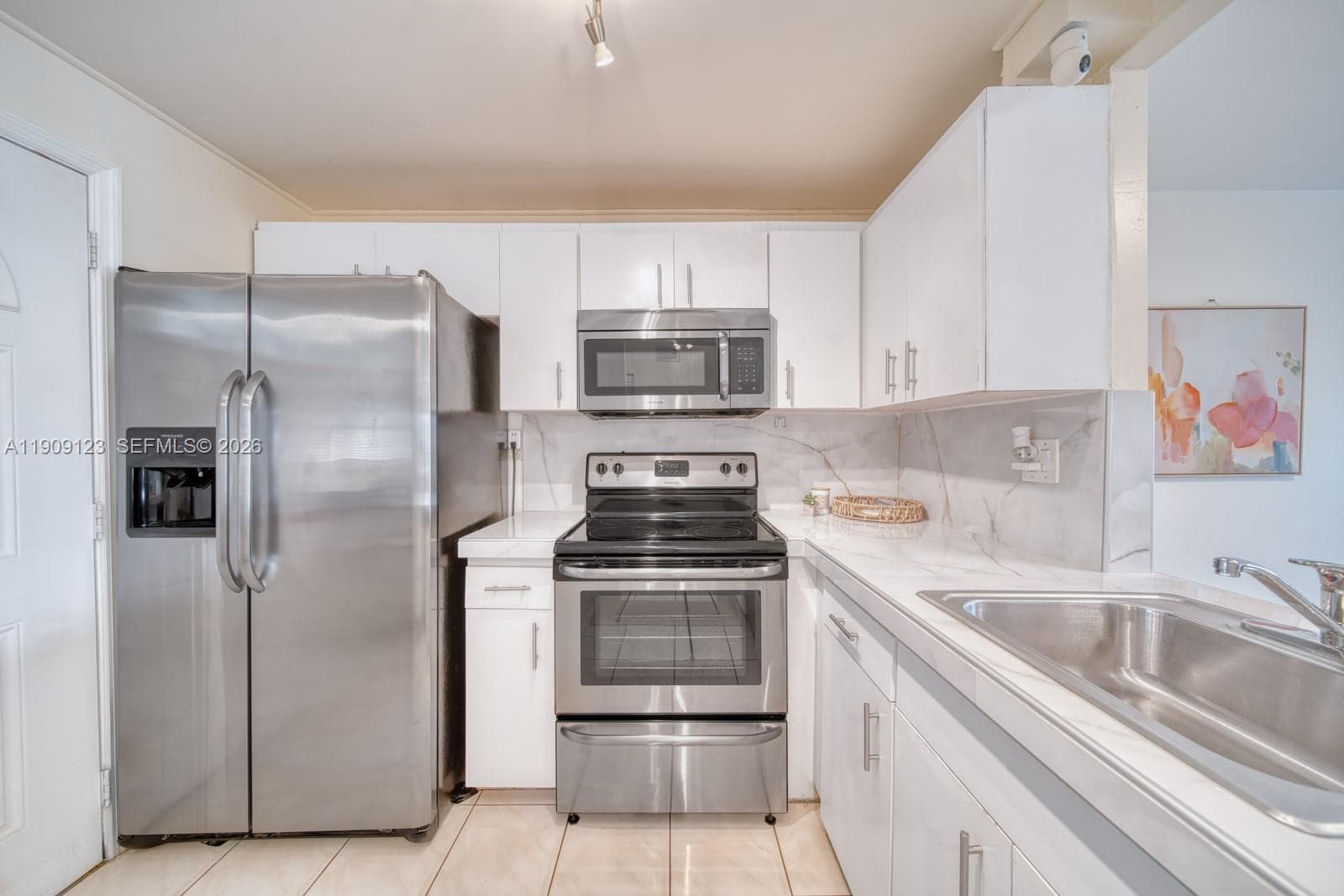 Open kitchen with white cabinetry, bar counter, and convenient breakfast bar.