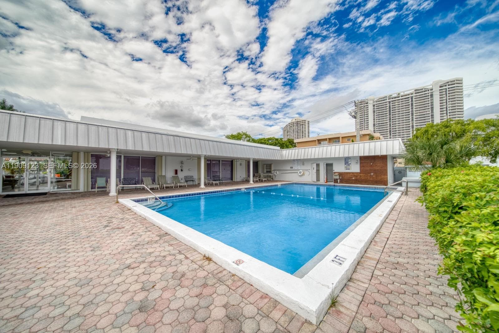 Resort-style pool with canal views and lounging area.