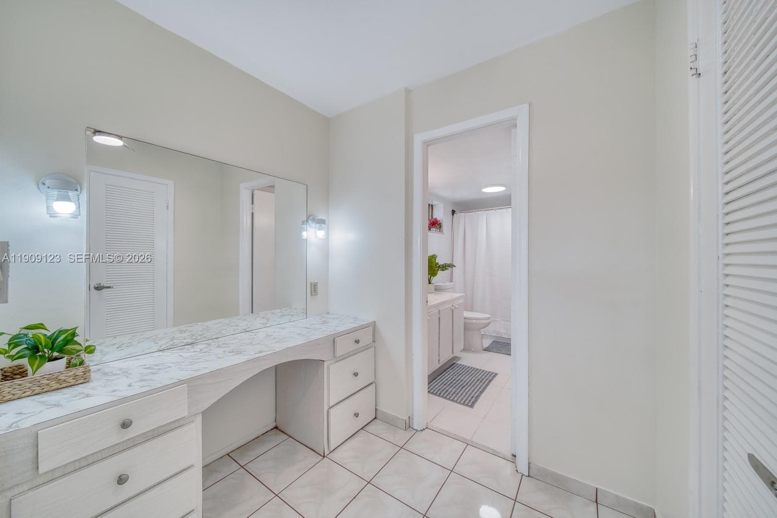 Comfortable second bedroom with mirrored closet doors and natural light.
