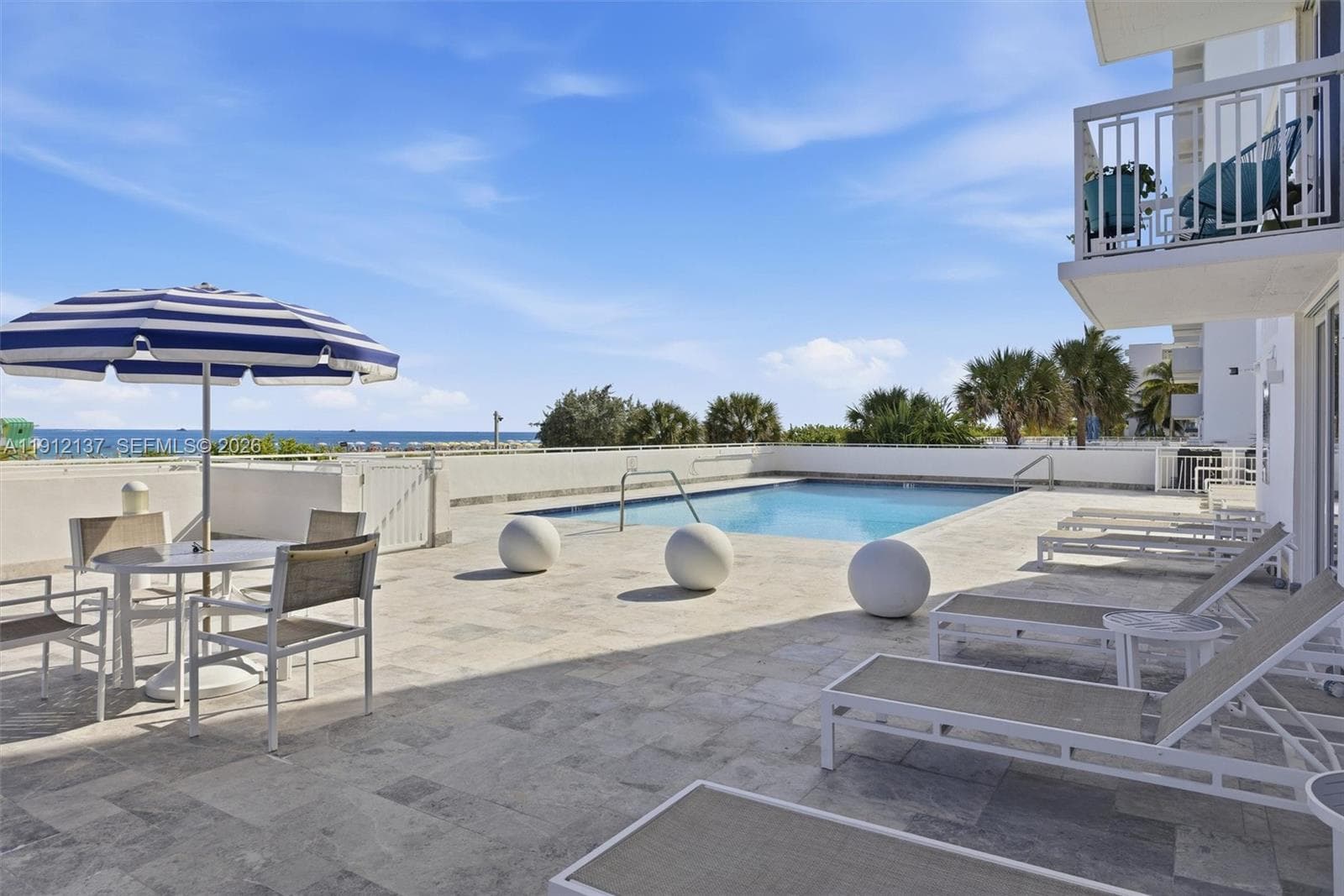 Enjoy the ultimate Miami Beach lifestyle at this oceanfront pool deck, where every swim comes with panoramic views of the Atlantic. Surrounded by tropical palms and bathed in sunshine, the sparkling pool offers a serene retreat just steps from the sand. Lounge in style on the expansive sundeck, unwind under the clear blue sky, or take in the breathtaking ocean vistas that stretch endlessly to the horizon.