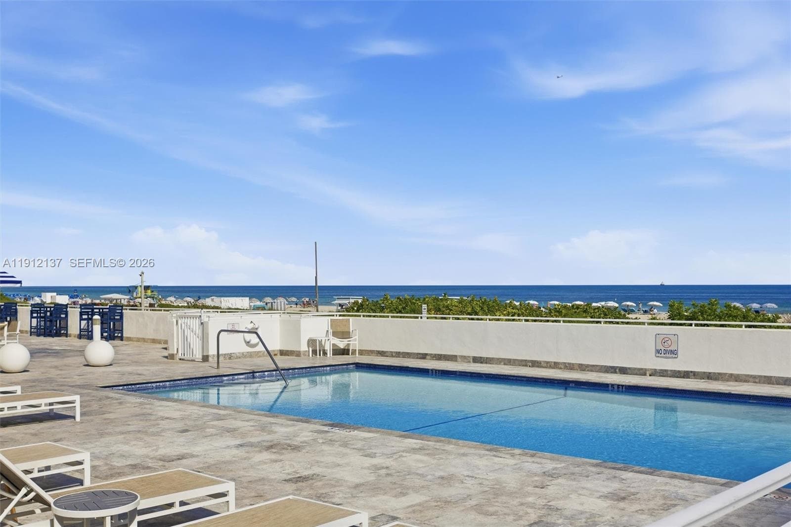 Enjoy the ultimate Miami Beach lifestyle at this oceanfront pool deck, where every swim comes with panoramic views of the Atlantic. Surrounded by tropical palms and bathed in sunshine, the sparkling pool offers a serene retreat just steps from the sand. Lounge in style on the expansive sundeck, unwind under the clear blue sky, or take in the breathtaking ocean vistas that stretch endlessly to the horizon.