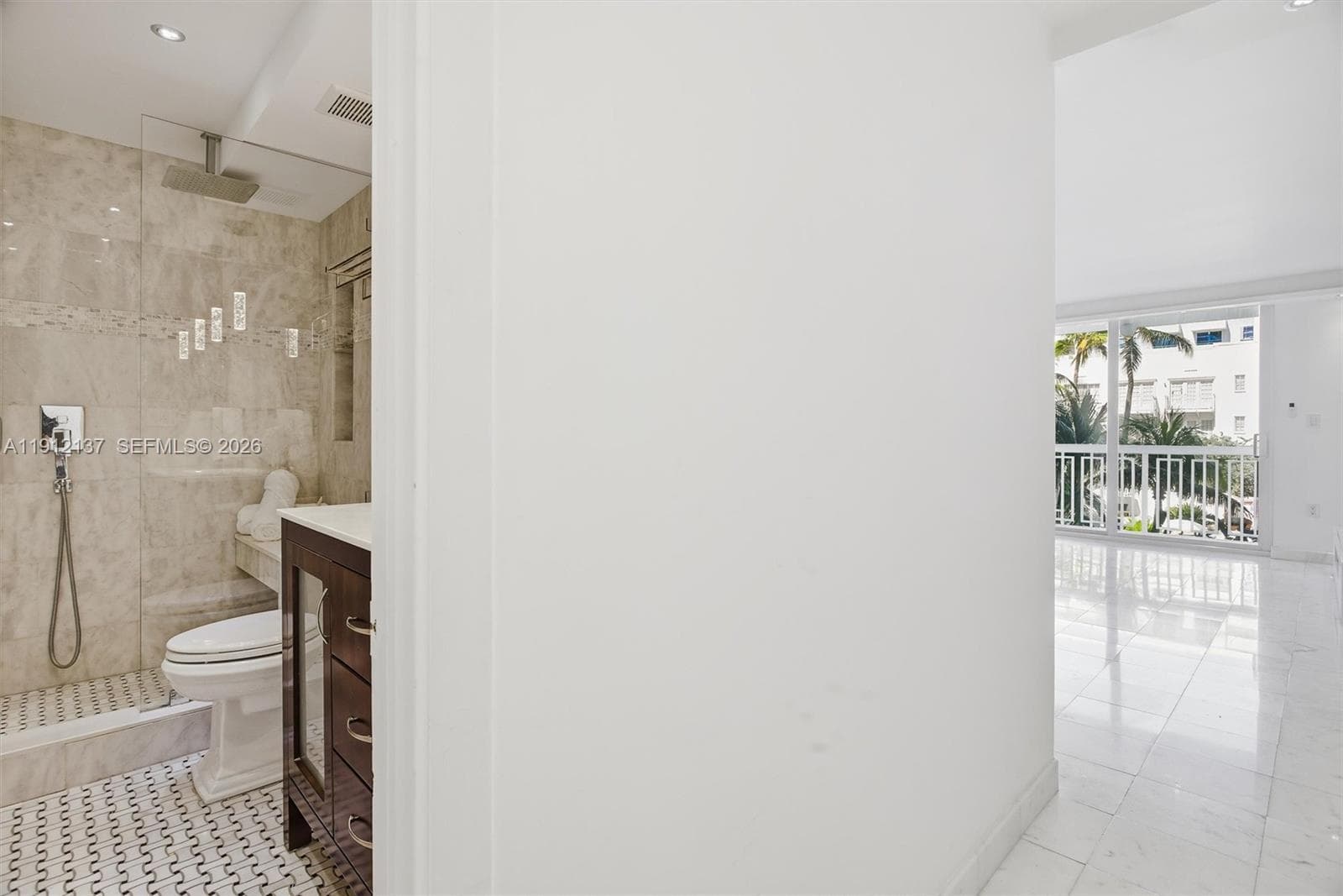 Step into this bright and elegant oceanfront studio, where modern design meets coastal serenity. Gleaming floors, floor-to-ceiling mirrors, and expansive sliding glass doors fill the space with natural light and offer lush views of palm trees and the ocean beyond. The open layout provides a perfect canvas for a luxurious living and sleeping area, while refined finishes and recessed lighting create a sophisticated ambiance