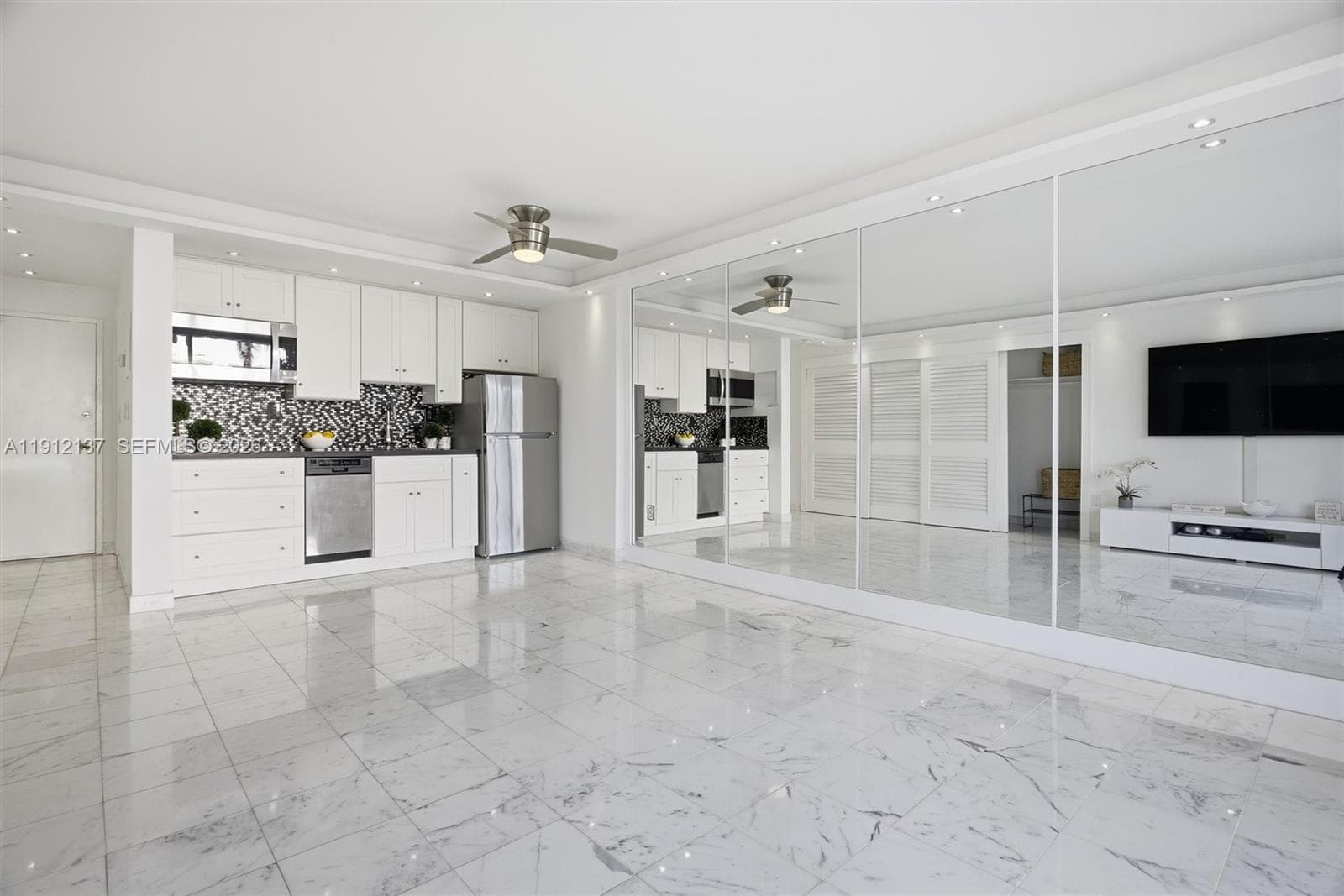 Step into this bright and elegant oceanfront studio, where modern design meets coastal serenity. Gleaming floors, floor-to-ceiling mirrors, and expansive sliding glass doors fill the space with natural light and offer lush views of palm trees and the ocean beyond. The open layout provides a perfect canvas for a luxurious living and sleeping area, while refined finishes and recessed lighting create a sophisticated ambiance