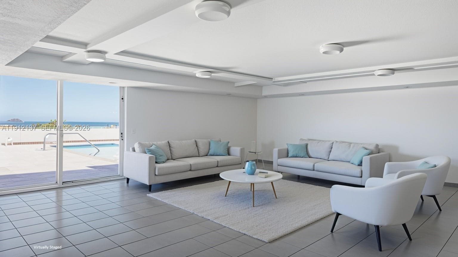 This bright and versatile recreational room offers the perfect space for gatherings, fitness, or relaxation. Framed by floor-to-ceiling windows that open to the oceanfront pool deck, the room is filled with natural light and coastal views. Its open layout and modern design provide endless possibilities — from hosting social events to creating a serene yoga or wellness space. With direct access to the pool and breathtaking ocean backdrop, this amenity embodies the effortless indoor-outdoor lifestyle