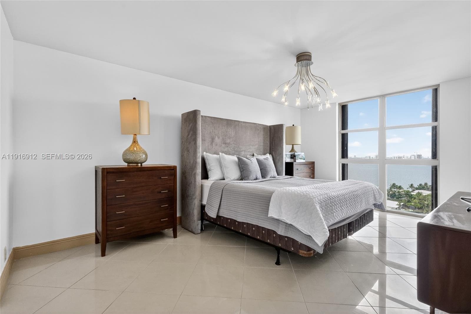 The primary bedroom offers an expansive, light-filled retreat with sweeping views of Miami’s skyline and the sparkling waterfront