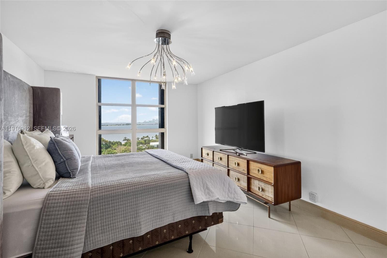 This oversized primary suite features soaring space and floor-to-ceiling windows that frame breathtaking views of the Miami skyline and tranquil blue waters