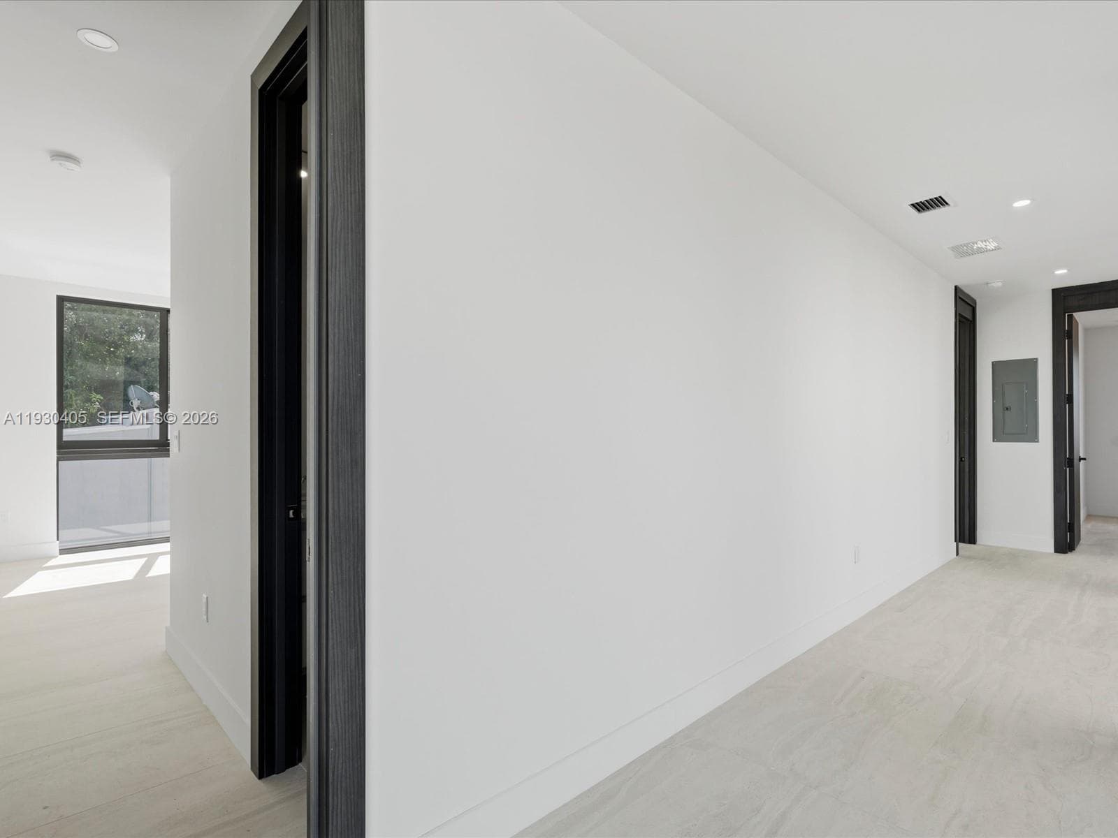 Interior space featuring wood-finish flooring, recessed lighting, and bold dark-toned door casings