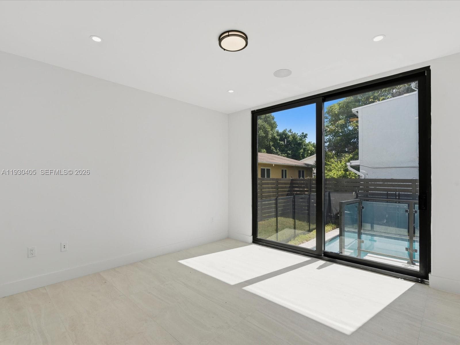 Interior space featuring wood-finish flooring, recessed lighting, a flush-mount ceiling fixture, and a floor-to-ceiling sliding glass door