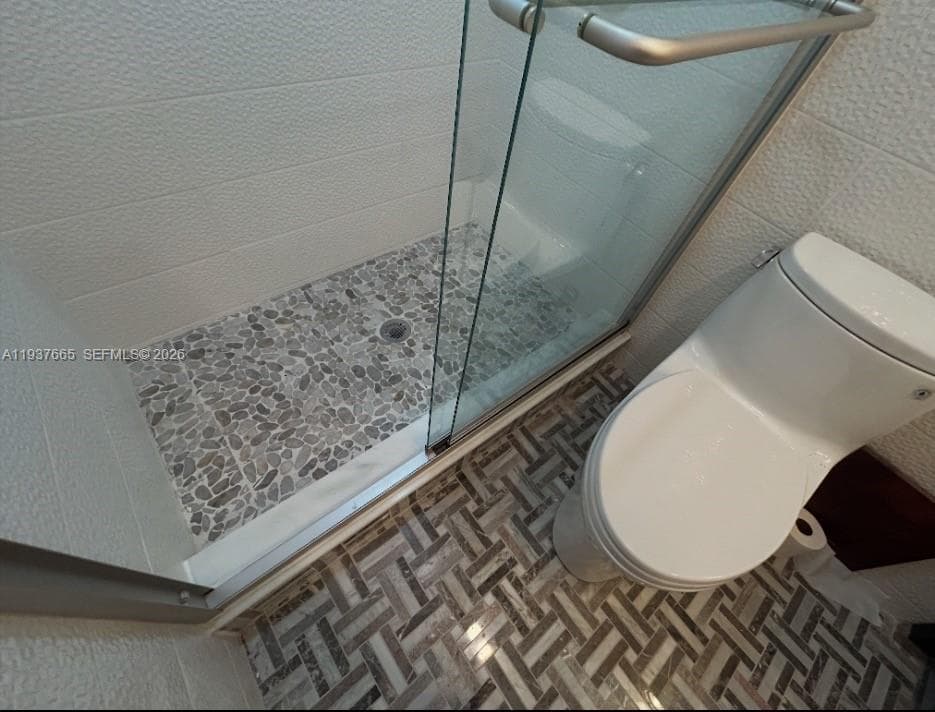 second bathroom double sinks with marble mosaic floors. and tile walls