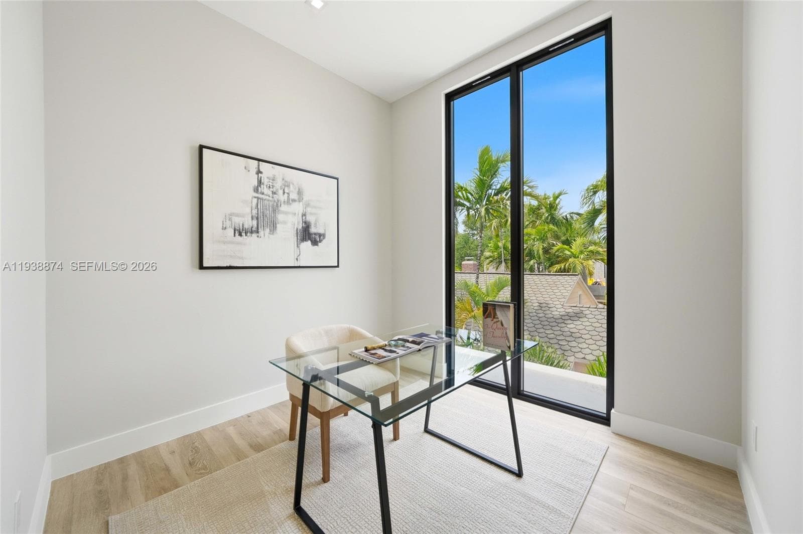 Floor-to-ceiling black-framed window featuring exterior landscaping, wood-finish flooring, and recessed lighting