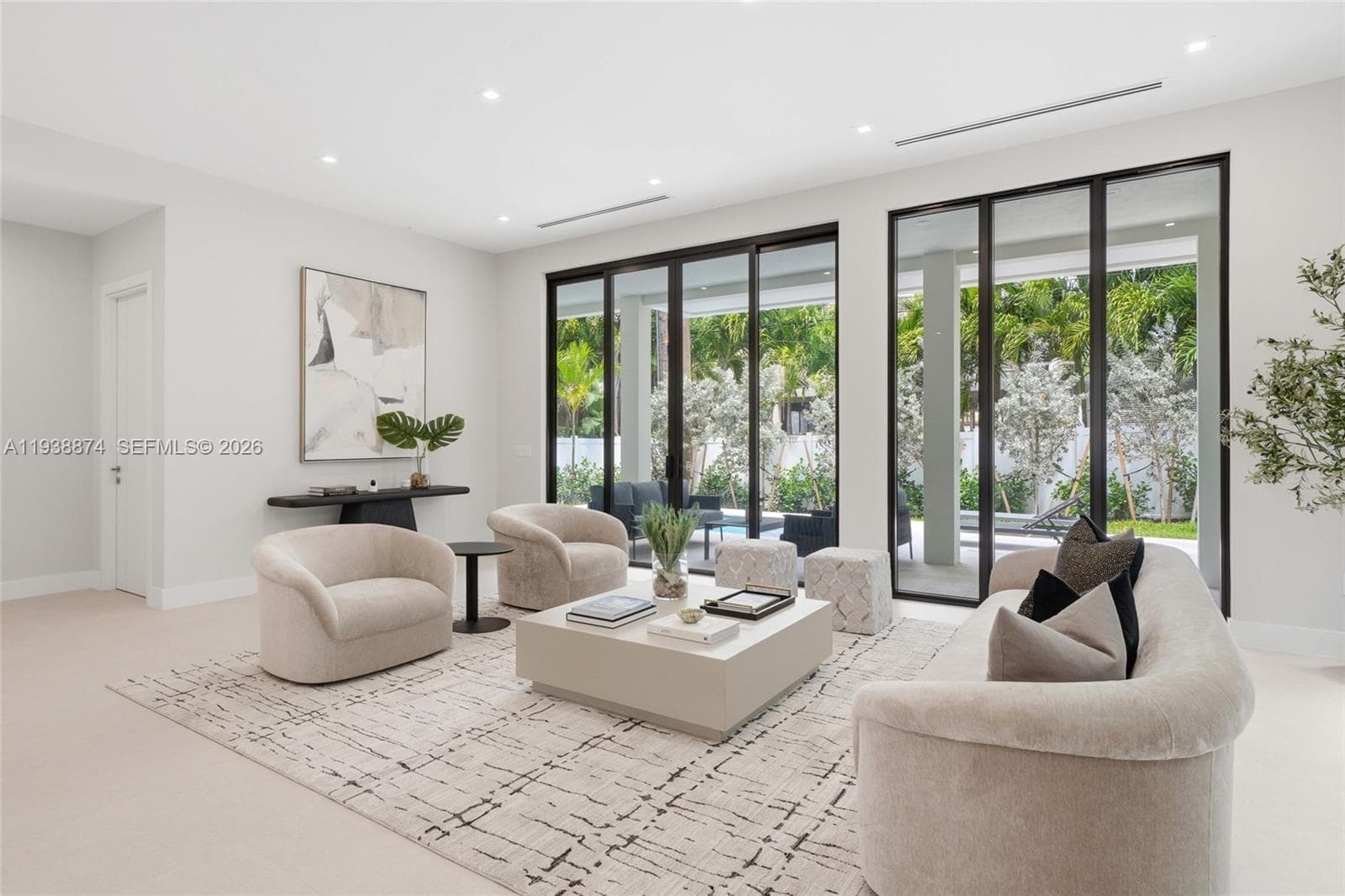 Floor-to-ceiling black-framed sliding glass doors, recessed ceiling lighting, linear air diffusers, and neutral wall-to-wall carpeting