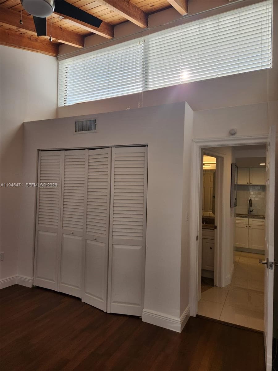 Second bedroom shows clerestory window and high ceilings.
