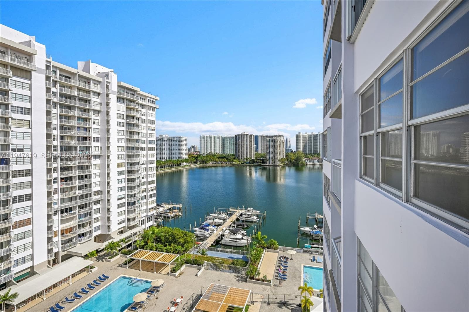 Serene balcony with pool, marina, and bay views.