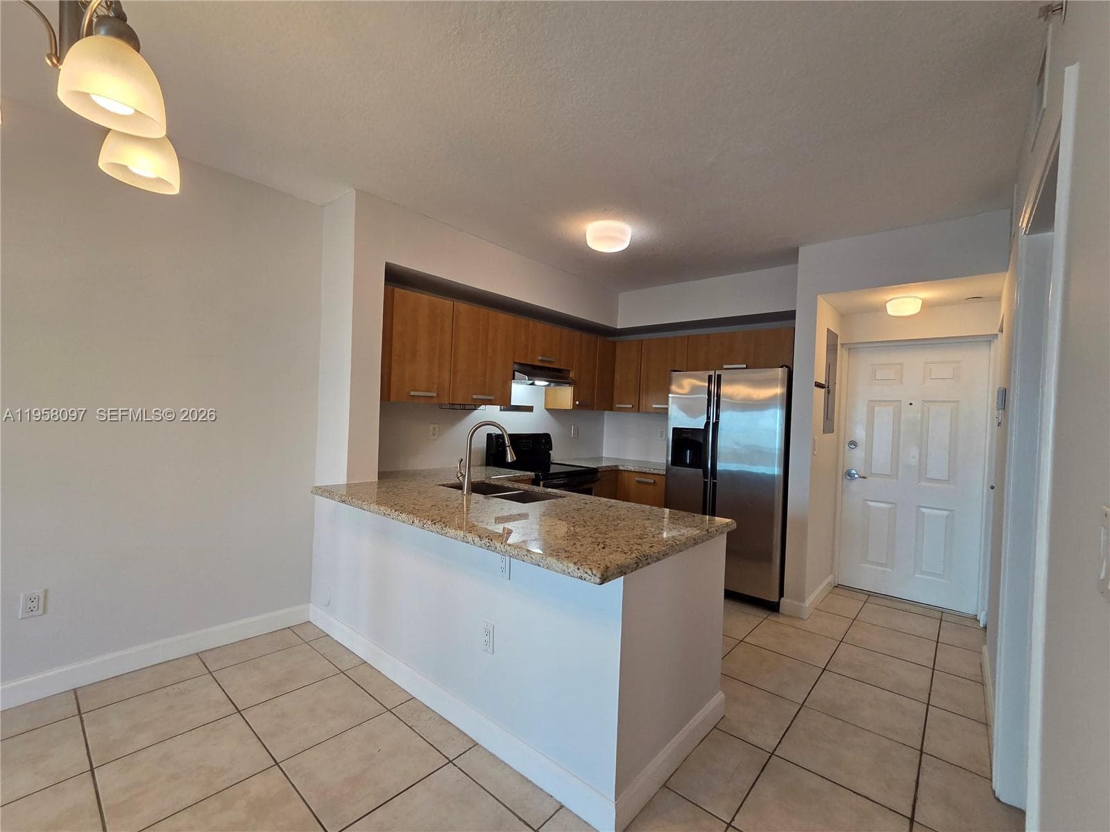 Open kitchen concept with peninsula seating, ideal for entertaining while maintaining separation of spaces.