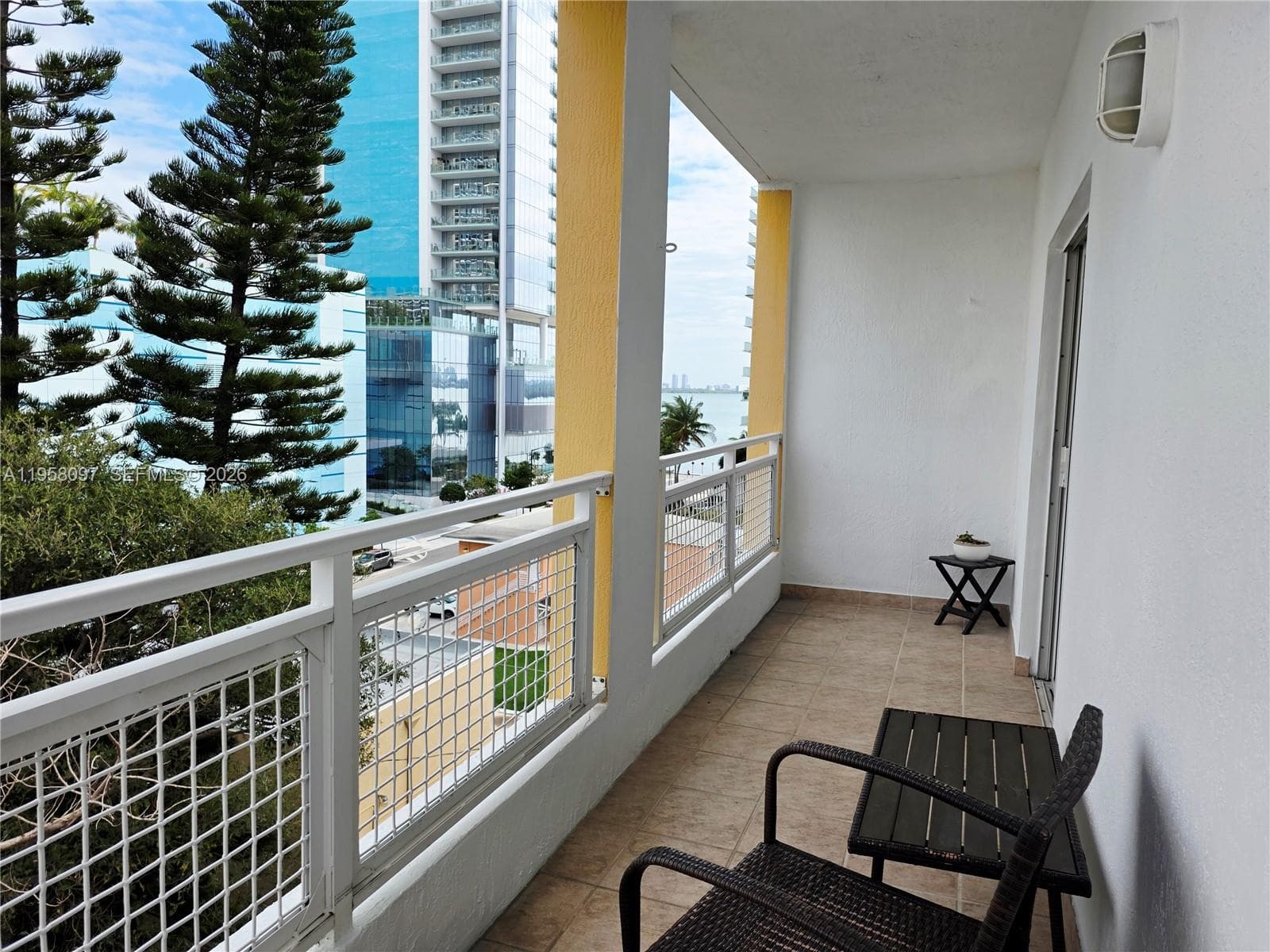 Private balcony with tile flooring and seating area.