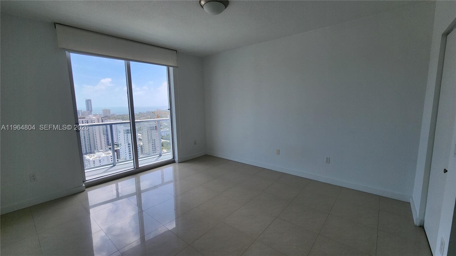 Spacious bedroom with amazing water and city open views, and door to balcony