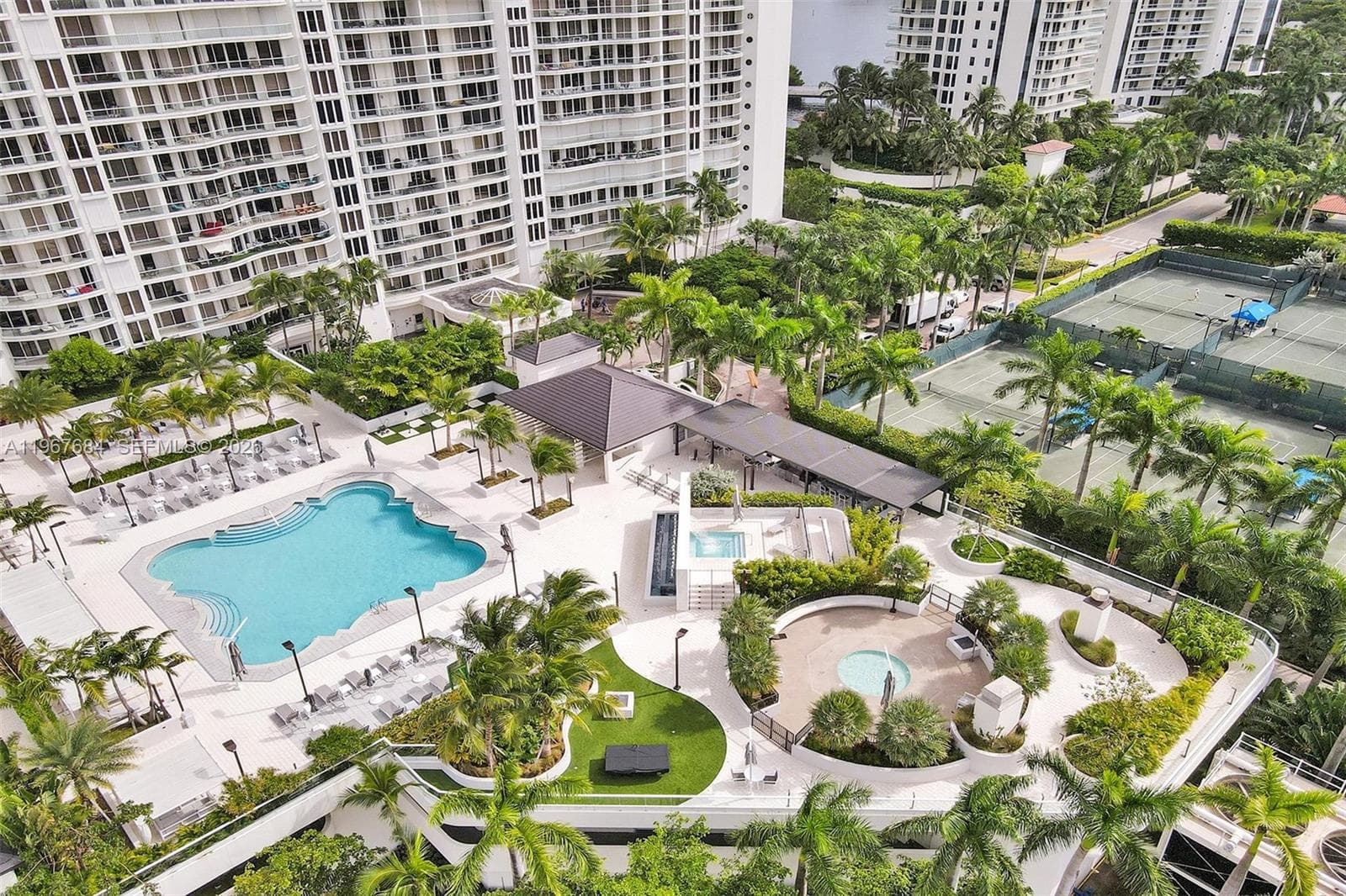 Pool, jacuzzi and BBQ area seen from a drone.