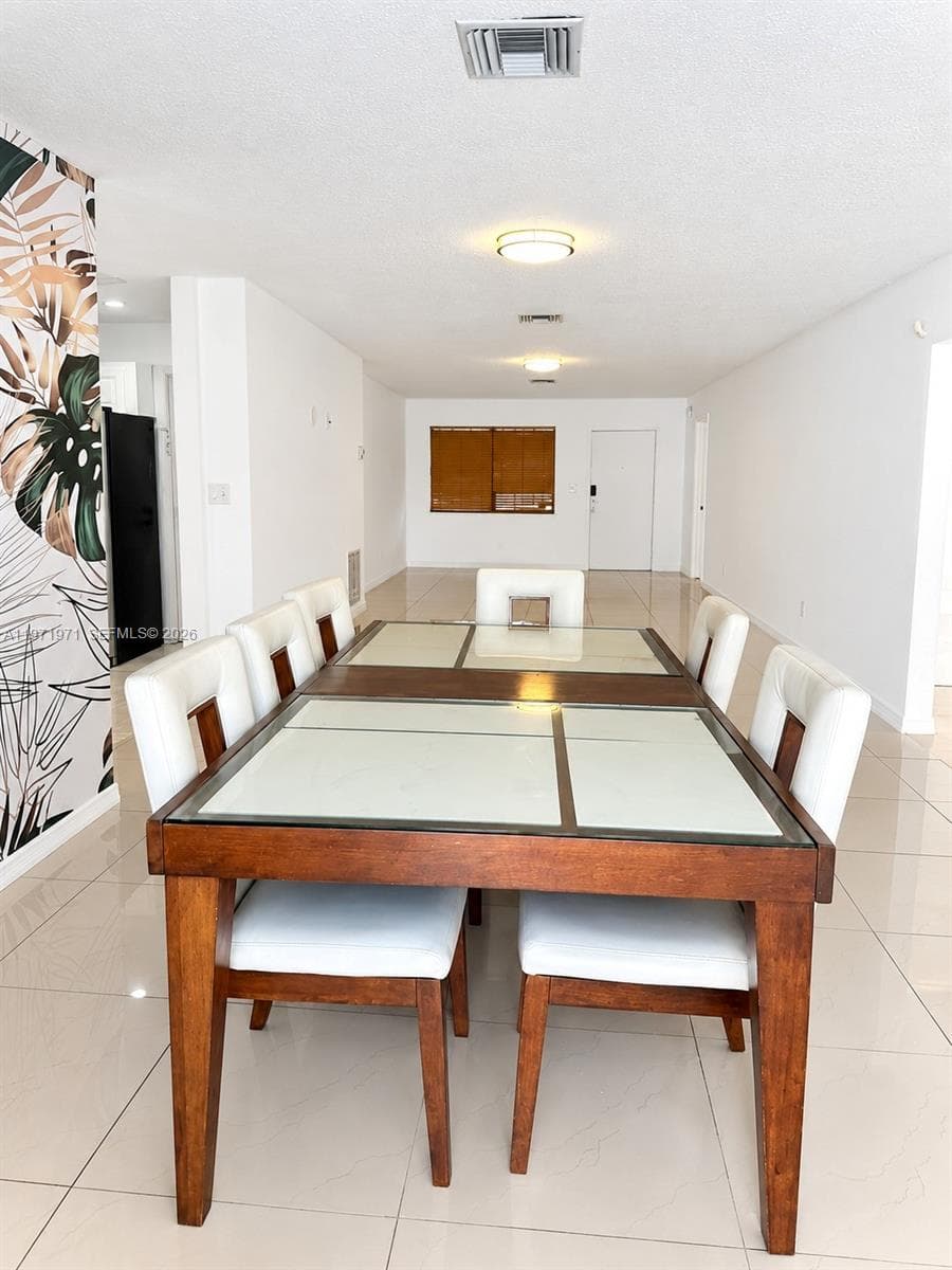Open-concept space featuring polished tile flooring, flush-mount ceiling lighting, and a botanical-patterned accent wall