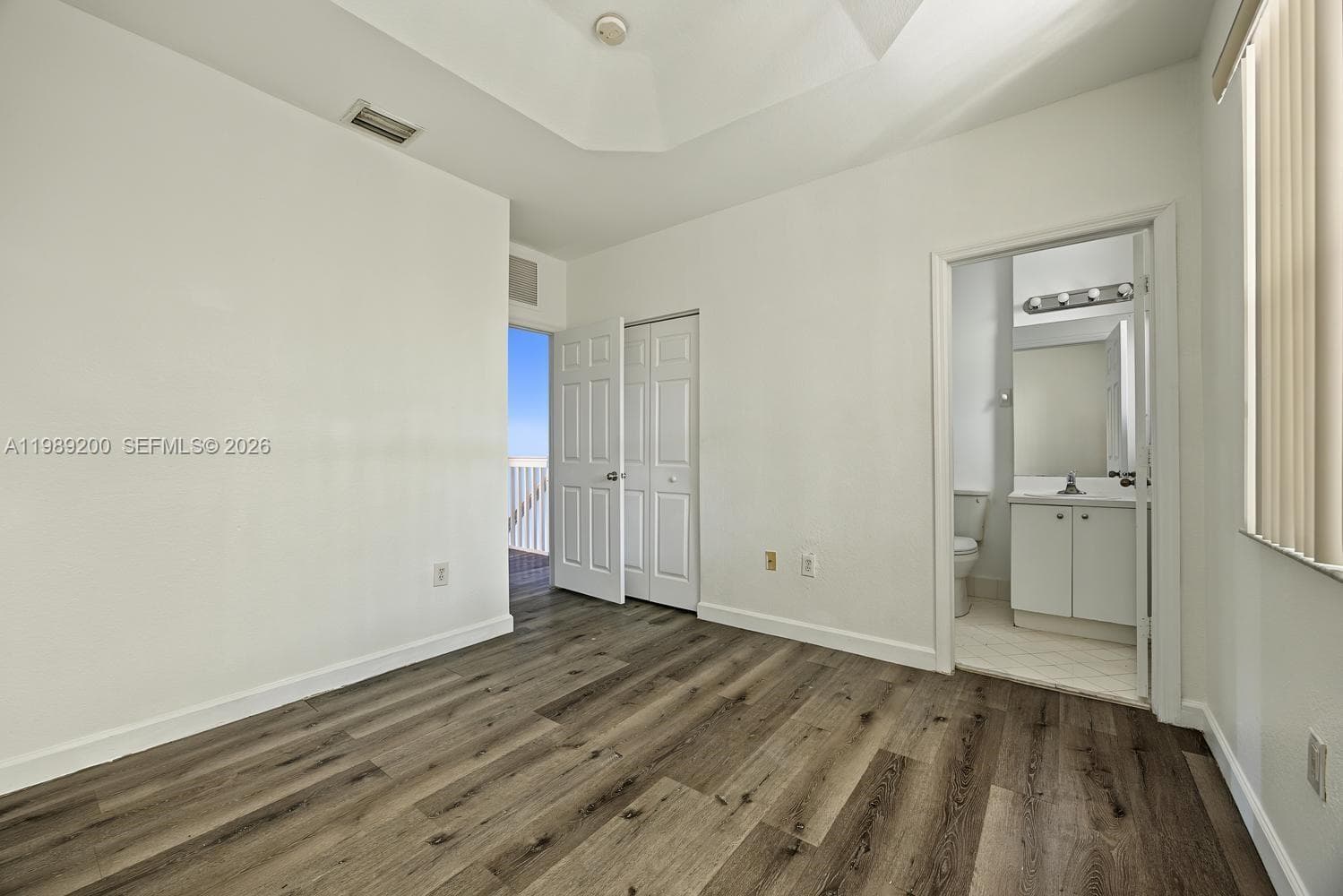 Room featuring vaulted ceilings, wood-finish flooring, and dual-panel interior doors