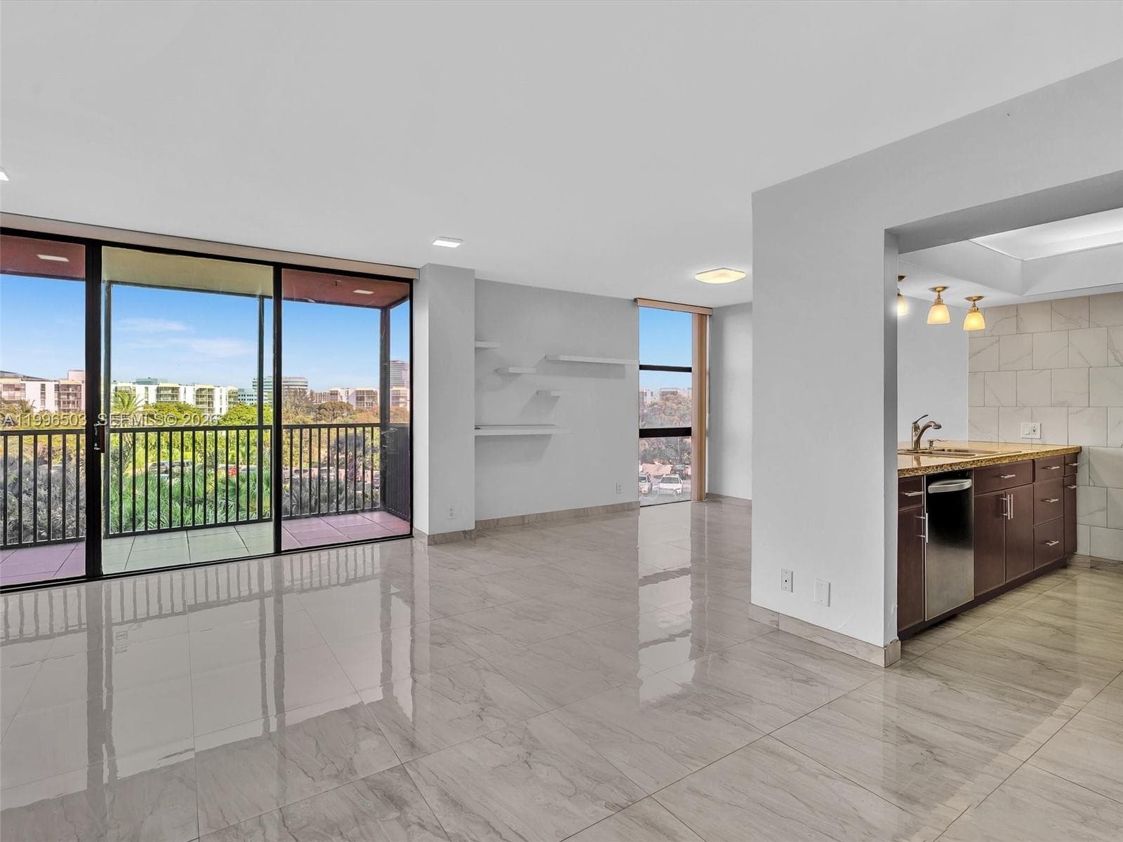 Open living area with balcony view and kitchen access