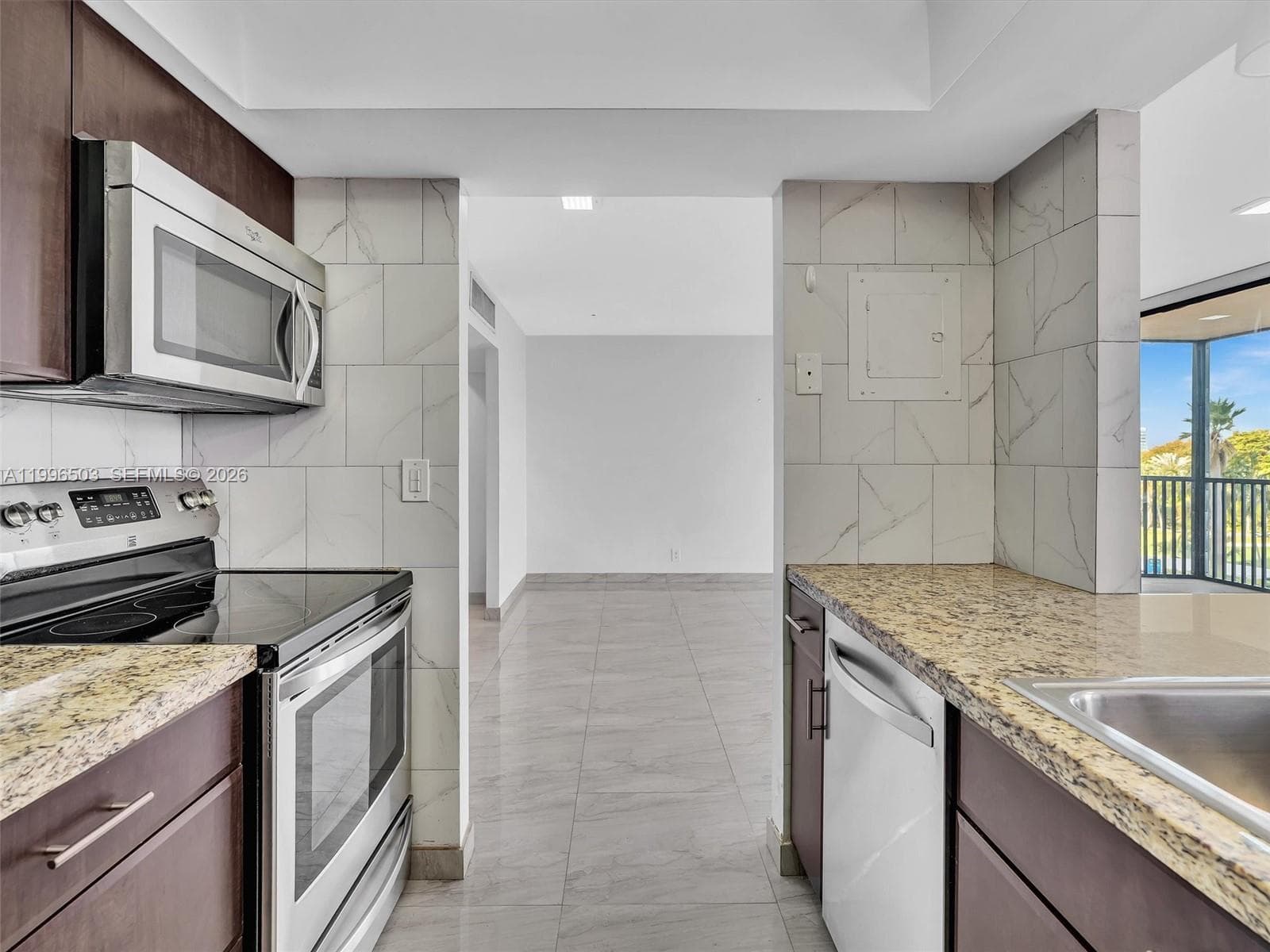 View into Kitchen with granite countertops and stainless steel appliances