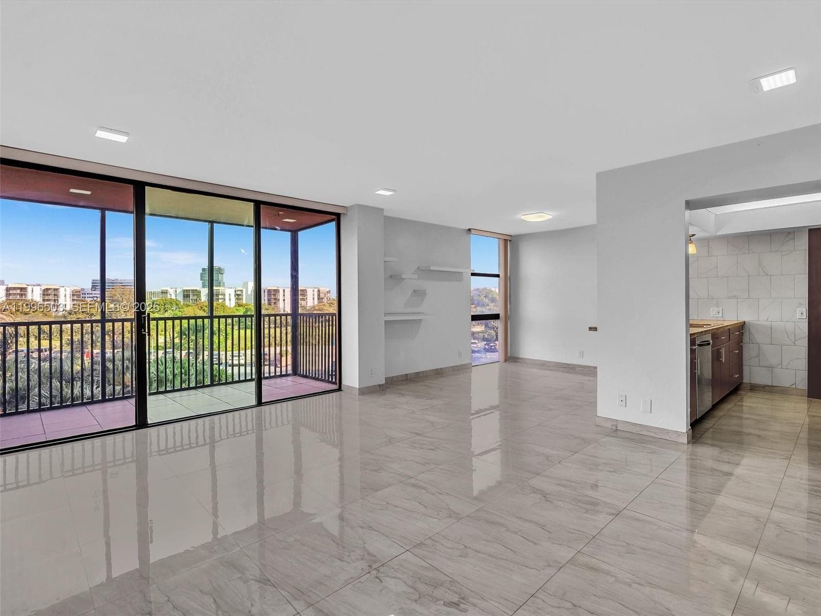 Spacious living area with extended open layout and balcony view