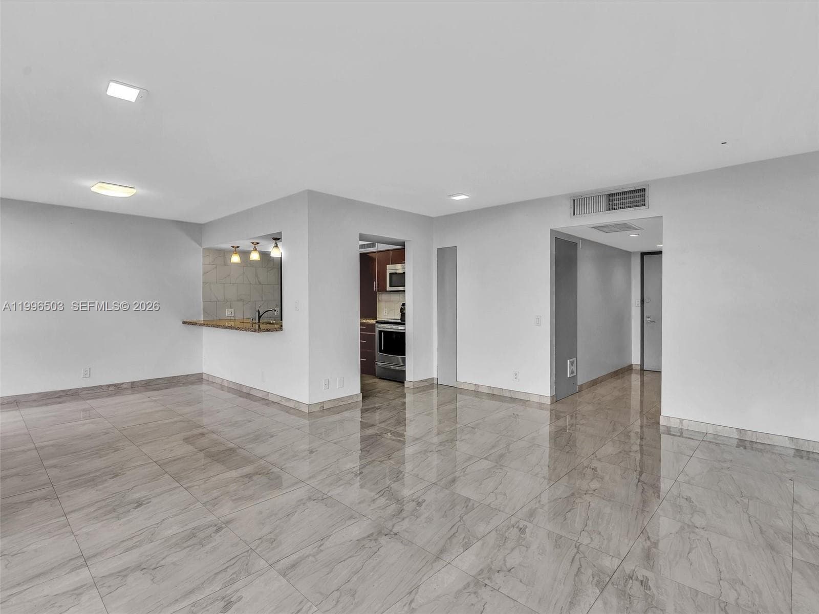 Living room from another angle showing open layout and Kitchen access