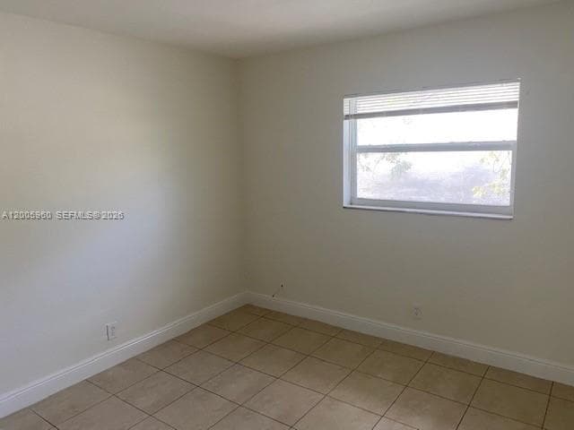 Neutral-toned walls, tile flooring, and a single-pane window