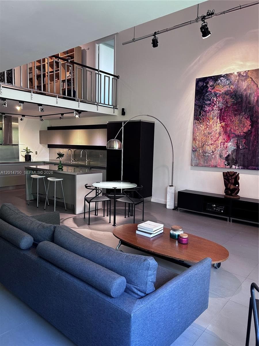 View of living area into kitchen and loft above.