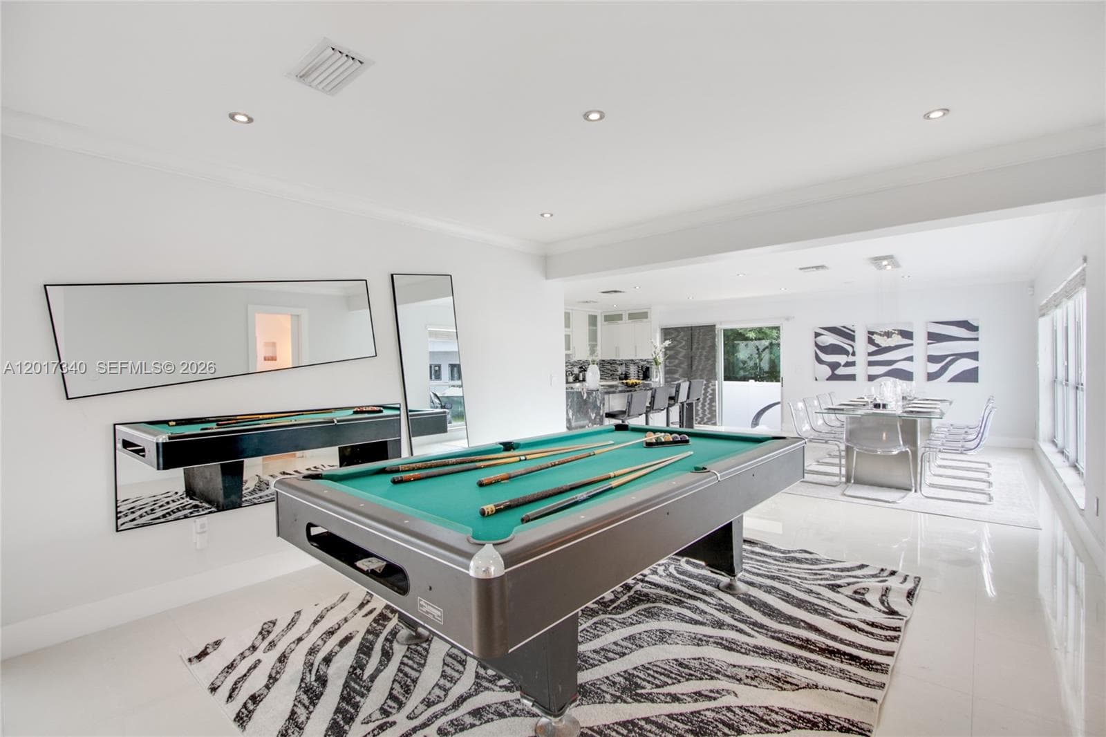 Open-concept interior featuring polished tile flooring, recessed ceiling lighting, and crown molding