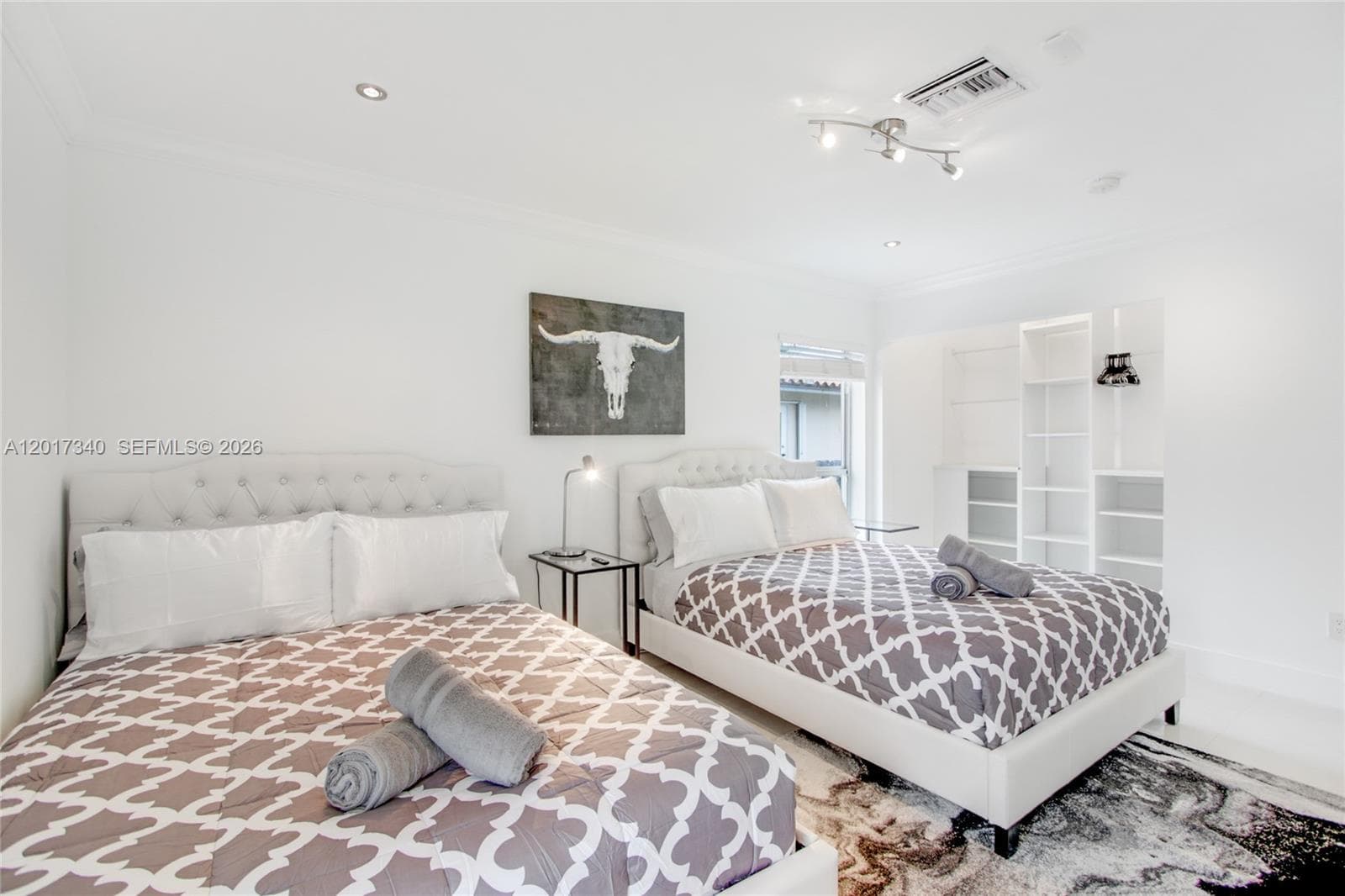 Room featuring crown molding, built-in floor-to-ceiling shelving, recessed lighting, and a multi-directional track light fixture