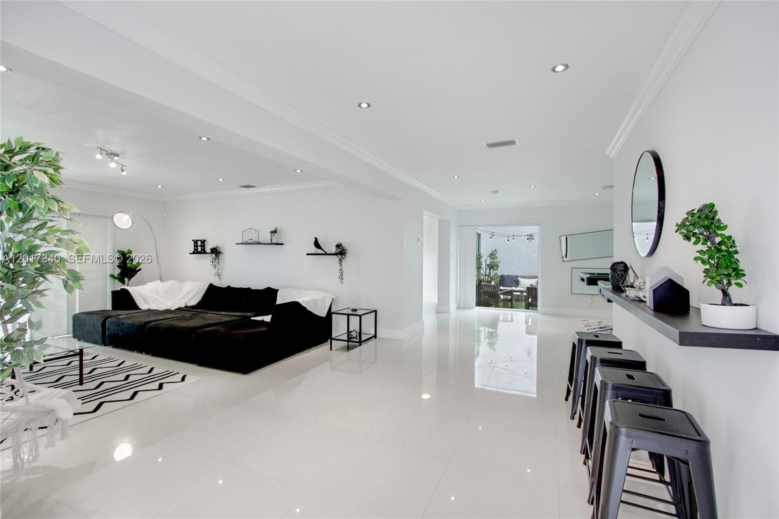 Large-format white tile flooring, recessed ceiling lighting, crown molding, and built-in wall shelving