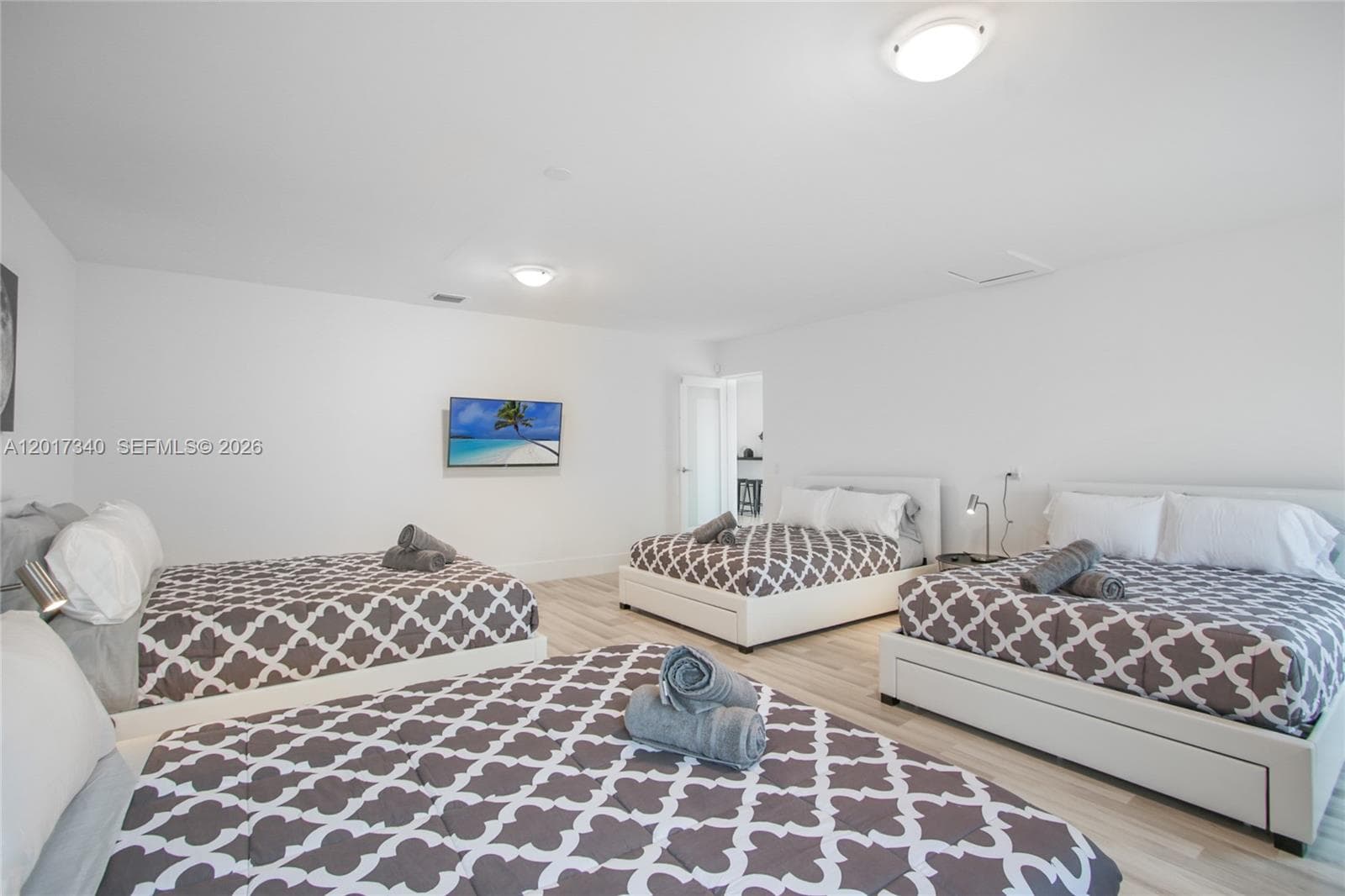 Spacious room featuring wood-finish flooring, neutral wall tones, and recessed overhead lighting