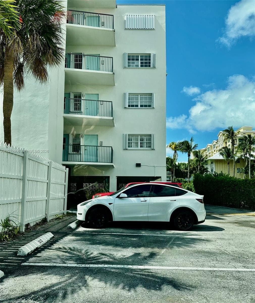 Parking Space 206, where the white car is parked, is located  by stairs below unit.
