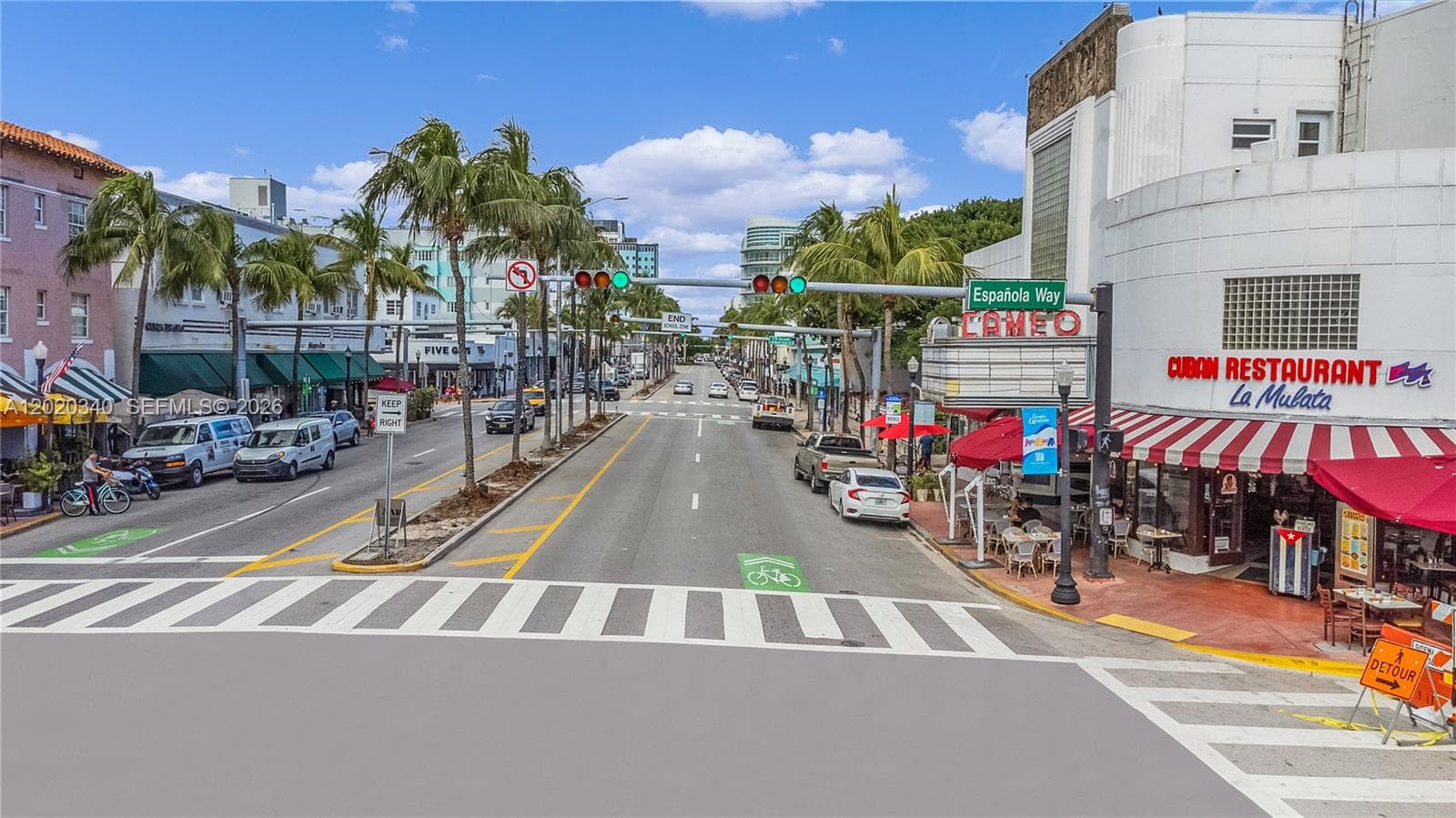 The iconic Española Way intersection in Miami Beach — lined with palm trees, Art Deco buildings, outdoor cafés, the historic Cameo theater, and a Cuban restaurant. Walkable, vibrant, and quintessentially South Beach.