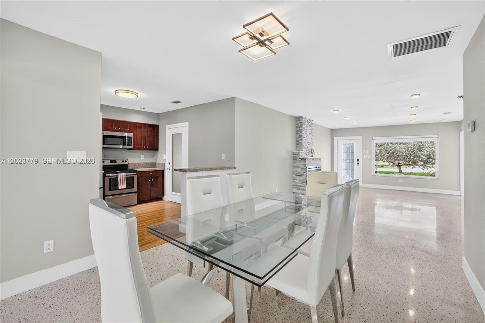 Dining area with flushmount fixture next to open concept kitchen