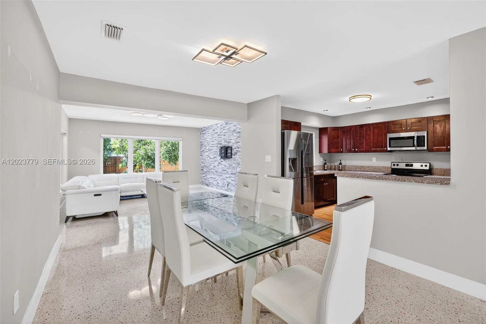 Dining area with flushmount fixture next to open concept kitchen