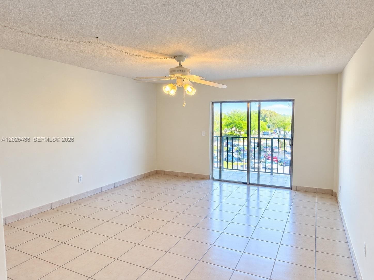 Empty-Ceramic tile flooring, ceiling fan with integrated light fixture, and sliding glass doors opening to a private balcony